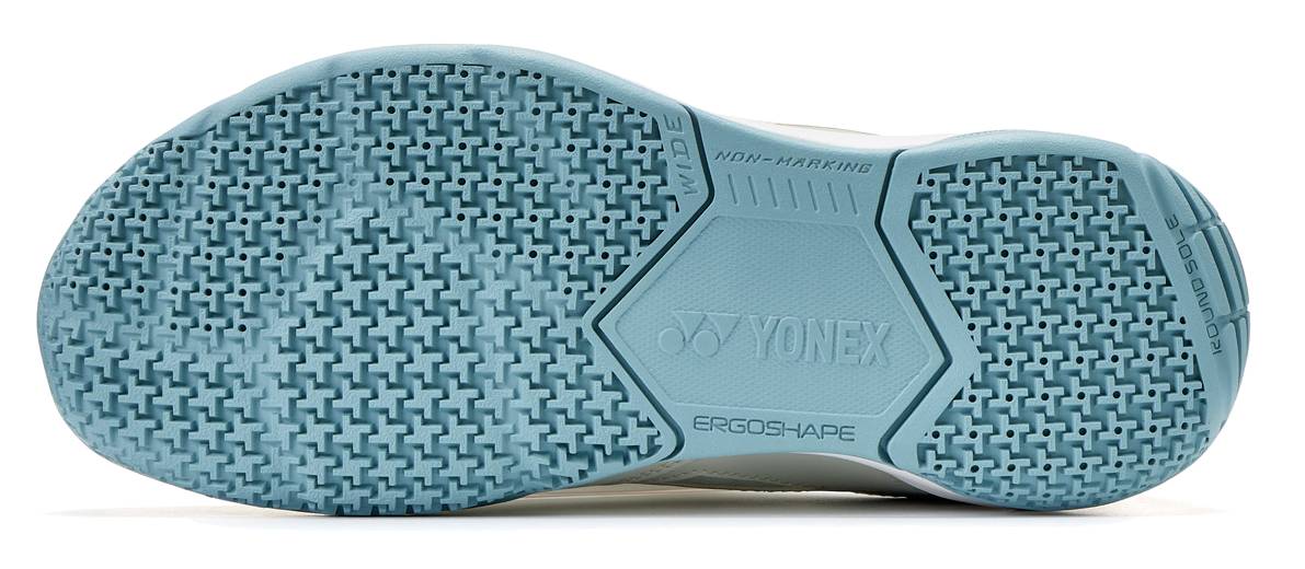 The Yonex Power Cushion Strider Ray Unisex WIDE Badminton Shoes in Blue Grey have a light blue, textured, non-marking sole with "YONEX," "ERGOSHAPE," and "NON-MARKING" molded in, offering wide fit comfort and Power Cushion support.