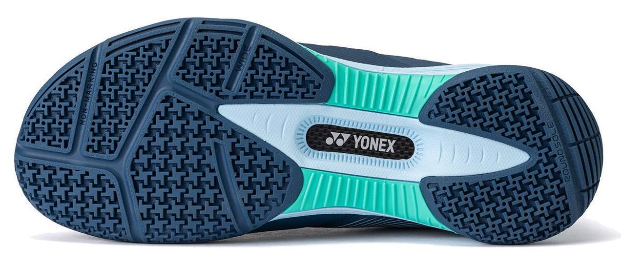 The image displays the sole of the Yonex Power Cushion 88 Dial 3 Wide Unisex Badminton Shoes in Navy / White by Yonex. The sole features a navy blue base with light blue and teal accents, showcasing textured patterns for enhanced grip. Specifically designed as a wide badminton shoe, it incorporates the advanced BOA Fit System for a secure and customizable fit. The Yonex logo appears prominently at the center of the sole.