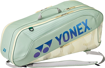 The Yonex 02626EX Expert 6 Racket Badminton Bag in Smoke Green features shoulder straps, handles, and blue-purple Yonex logo, plus Thermo Guard technology to protect your gear. Holds up to 6 rackets.