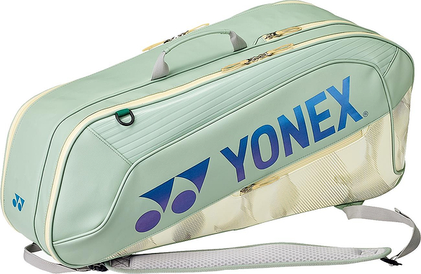The Yonex 02626EX Expert 6 Racket Badminton Bag in Smoke Green features shoulder straps, handles, and blue-purple Yonex logo, plus Thermo Guard technology to protect your gear. Holds up to 6 rackets.