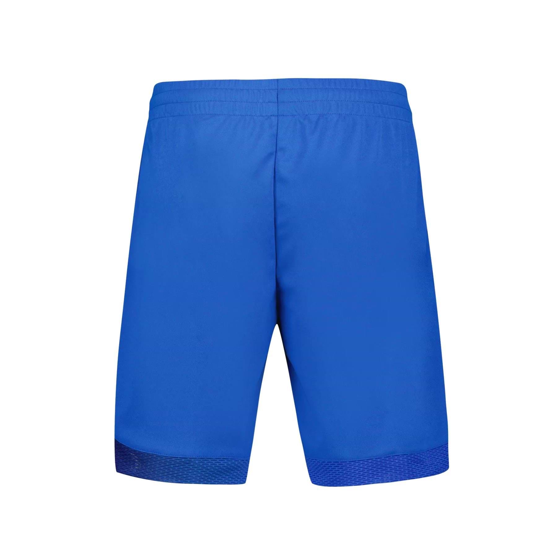 Back view of the Le Coq Sportif Pro Men's Badminton Shorts in Lapis Blue with an elastic waistband, set against a white background. Crafted from breathable material by Le Coq Sportif, these shorts ensure optimal dryness and showcase a minimalist design with no visible patterns or logos.