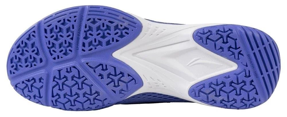 The image displays the sole of the Li-Ning Almighty V2.0 Unisex Badminton Shoes in Lilac/White, featuring a hexagonal and triangular tread pattern for superior grip, traction, and flexibility on the court.