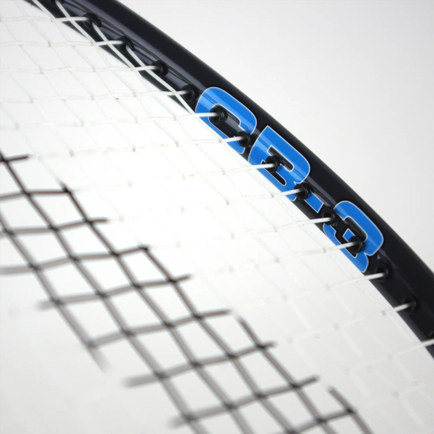 Close-up of a badminton racket highlighting the intricately woven strings and elegant black frame. The blue inscription "CB-3" prominently features on the frame, echoing the precision associated with the Karakal CB-3 2.1 Badminton Racket by Karakal. A plain, light background accentuates its isometric head design.