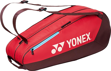 The Yonex 42526EX Team 6 Racket Badminton Bag in ruby red features a large white Yonex logo, multiple zippered compartments, and adjustable shoulder straps—perfect for stylishly carrying your badminton gear.