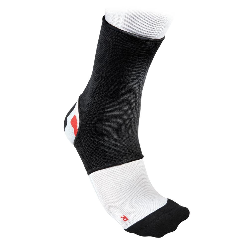 A McDavid 2-Way Elastic Ankle Sleeve in black and white is displayed on a foot. Its breathable fabric incorporates a reinforced heel and toe area highlighted with a red accent, offering elastic ankle support for comfort during athletic activities.