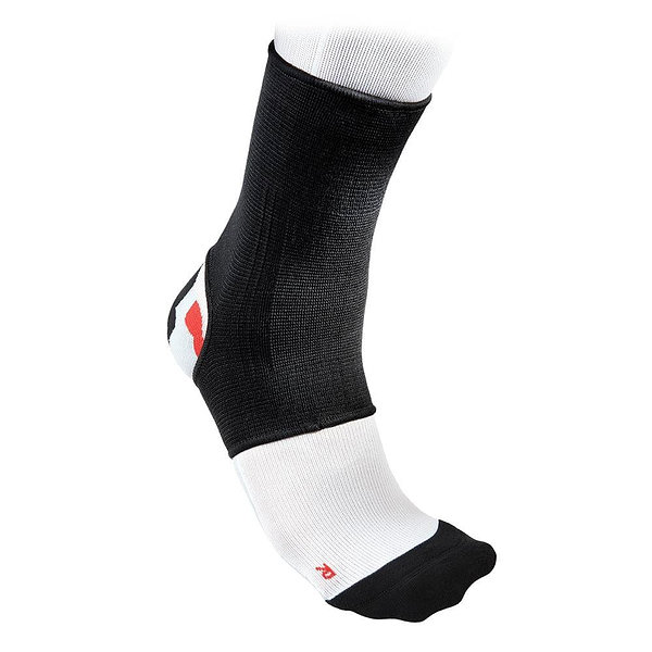 A McDavid 2-Way Elastic Ankle Sleeve in black and white is displayed on a foot. Its breathable fabric incorporates a reinforced heel and toe area highlighted with a red accent, offering elastic ankle support for comfort during athletic activities.