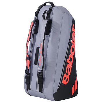 The Babolat RH6 Pure Strike 6 Racket Bag in Carbon Grey features black and red accents, multiple compartments—including a waterproof shoe section—and backpack straps. The bag is shown standing upright on a white background.
