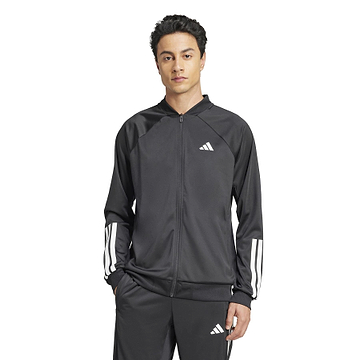 A person is wearing an ADIDAS Men's 3 Stripe Knit Badminton Jacket in black with white sleeve stripes. They stand against a plain white background with hands in their pockets.