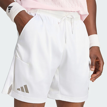 A person is shown from the waist to the upper legs, wearing white adidas Climacool Ergo Pro Mens Badminton Shorts and wristbands with their hands in their pockets, standing against a light background. The image highlights these quick-drying sports shorts from adidas, designed for both comfort and performance.
