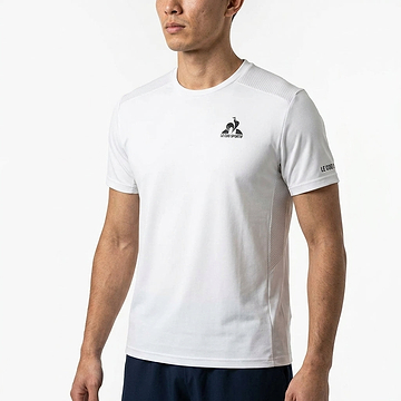 A man wears the Le Coq Sportif Pro Mens Badminton T-Shirt in Optical White, featuring a small chest and left sleeve logo. He stands against a white background, with only his upper body visible, highlighting this classic Le Coq Sportif style.