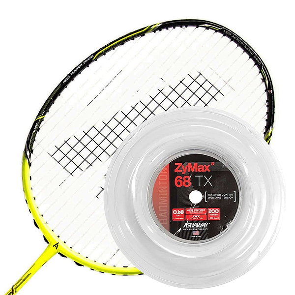 A badminton racket with black strings and a yellow frame is positioned behind a spool of Ashaway Zymax 68 TX Badminton String. This white string, featuring advanced ZyWeave string technology, comes on a clear 200m reel adorned with a black and red label showcasing detailed specifications.
