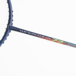 Close-up of a badminton racket with the name "Windstorm 72" on the shaft. The ultra-lightweight frame features a head-heavy balance design, is slim and orange, with visible string holes along the edge. The background is plain white.