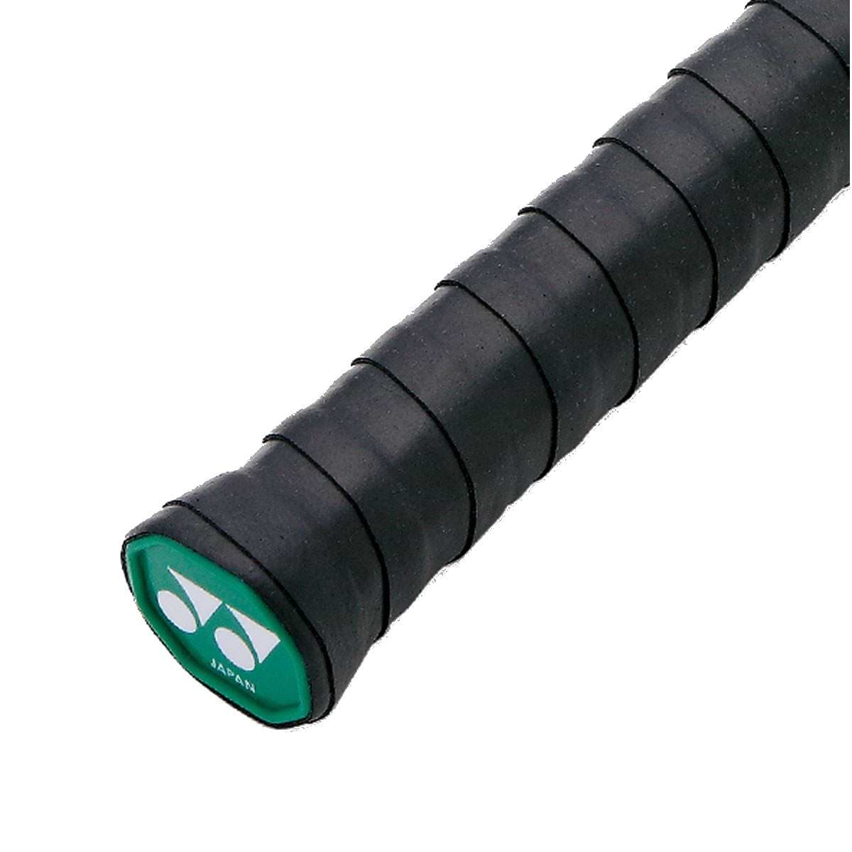 Close-up view of a black badminton racket handle, highlighting a green logo cap at the end with white symbols. The Yonex AC102EX Super Grap Badminton Overgrip - 3 Pack - Black offers textured grip tape for enhanced control, comfort, and sweat absorption while playing.