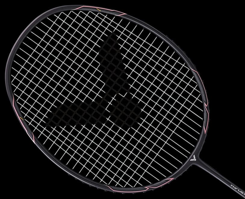 A Victor Thruster K1 H badminton racket, featuring a striking black and pink frame with white strings, is gracefully set against a black backdrop. The performance-enhancing strings form an intriguing crosshatch pattern that complements the racket's powerbox design.