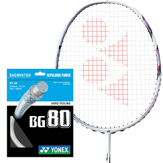 A Yonex badminton racket with a white frame and red strings is positioned beside a Yonex BG 80 Badminton String packet, featuring "Repulsion Power" and "Hard Feeling," attributed to its multifilament core and high-modulus Vectran fiber construction.