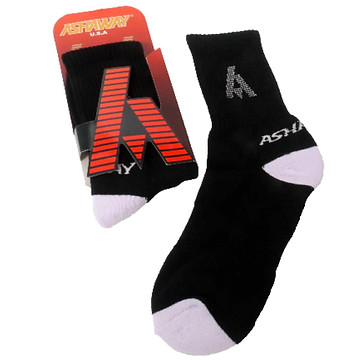 A pair of Ashaway Badminton Socks in black and white, designed for optimal performance in racket sports. One sock is shown laid out on a white background, with the other partially visible in its packaging. The socks feature a ribbed cuff and contrasting white toe area with a prominent Ashaway logo.