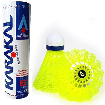 A set of six Karakal National Natural Nylon Shuttlecocks - Yellow Medium is displayed next to a single yellow shuttlecock with a white tip. The blue and white tube features Karakal branding and product details. These nylon shuttlecocks showcase an intricate nylon skirt design and include natural cork bases for optimal performance.