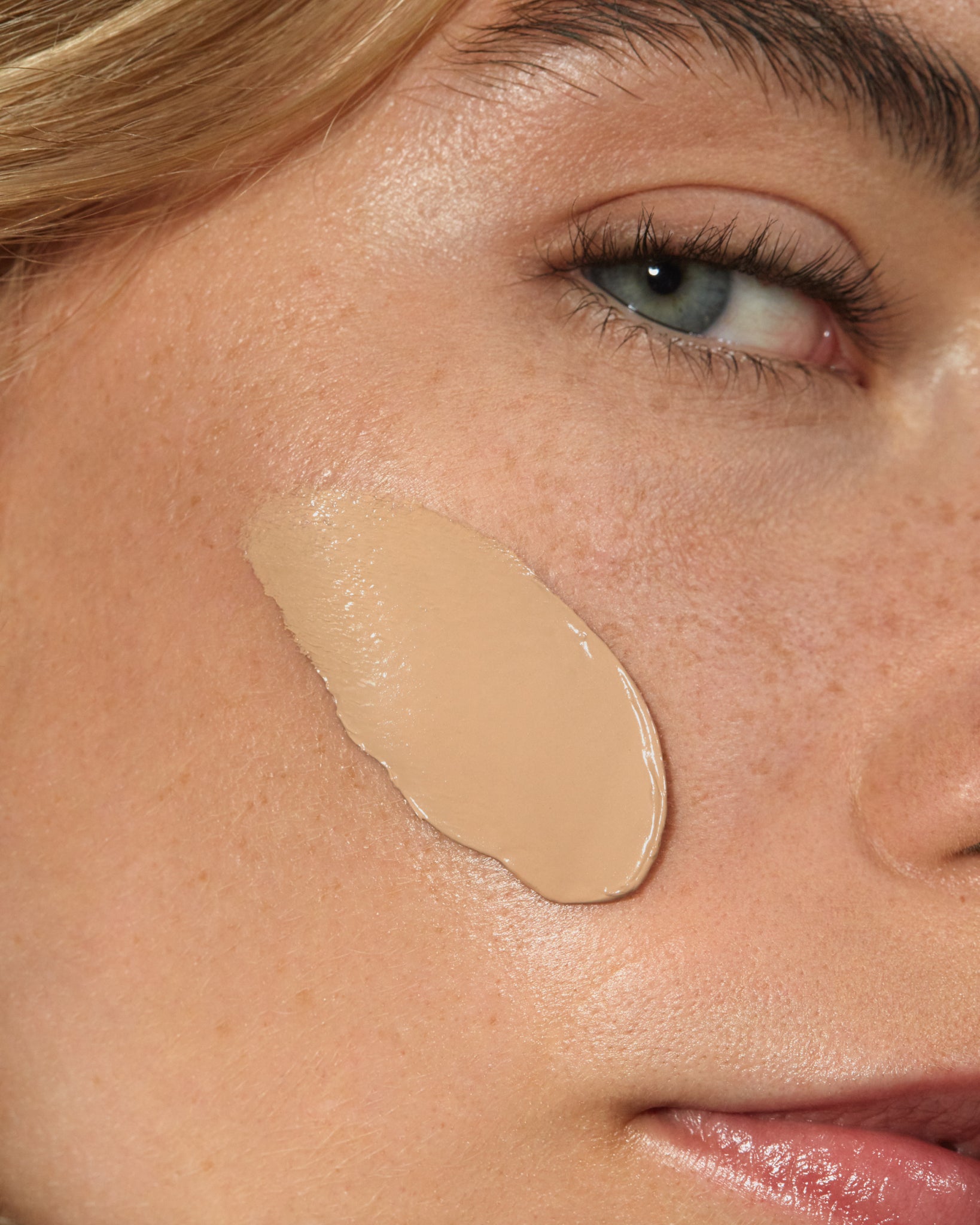 Model wearing MÁDARA Organic Skincare skinonym sand on A6085 on skin; close-up portrait shows natural application results.