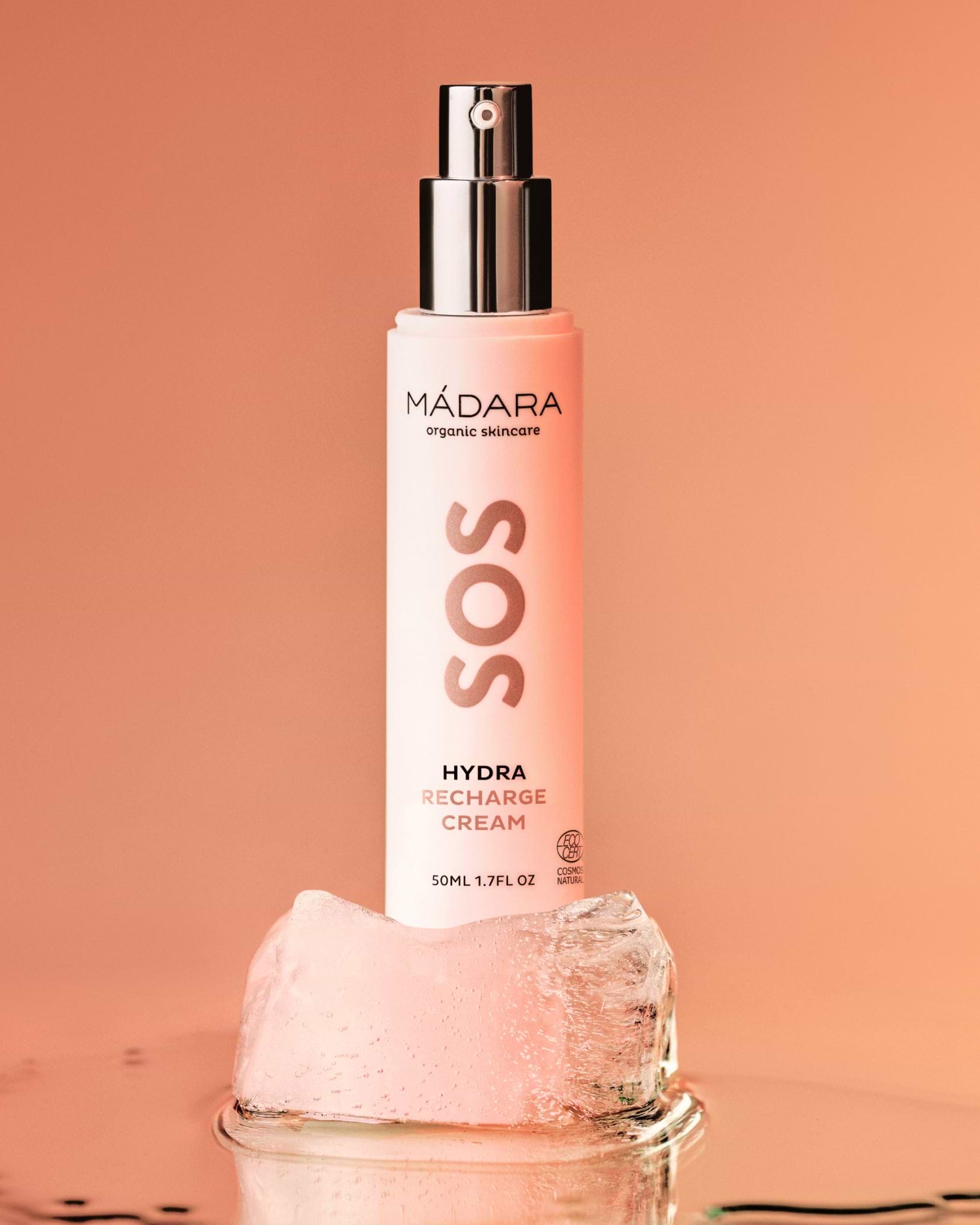 Mádara SOS Hydra Recharge Organic Face Cream bottle on a peach background