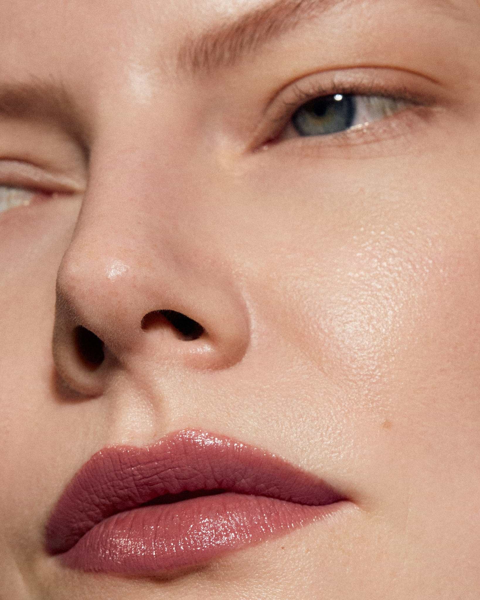 Model wearing MÁDARA Organic Skincare satin shine lipstick charisma on A6503 on skin; close-up portrait shows natural application results.