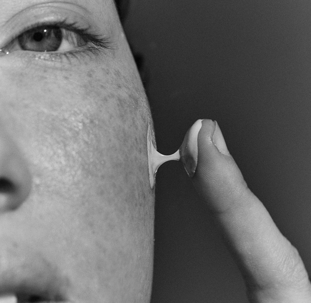 Primer plano de la textura natural de la piel con crema solar aplicada, que destaca la fórmula mineral ligera con factor de protección solar