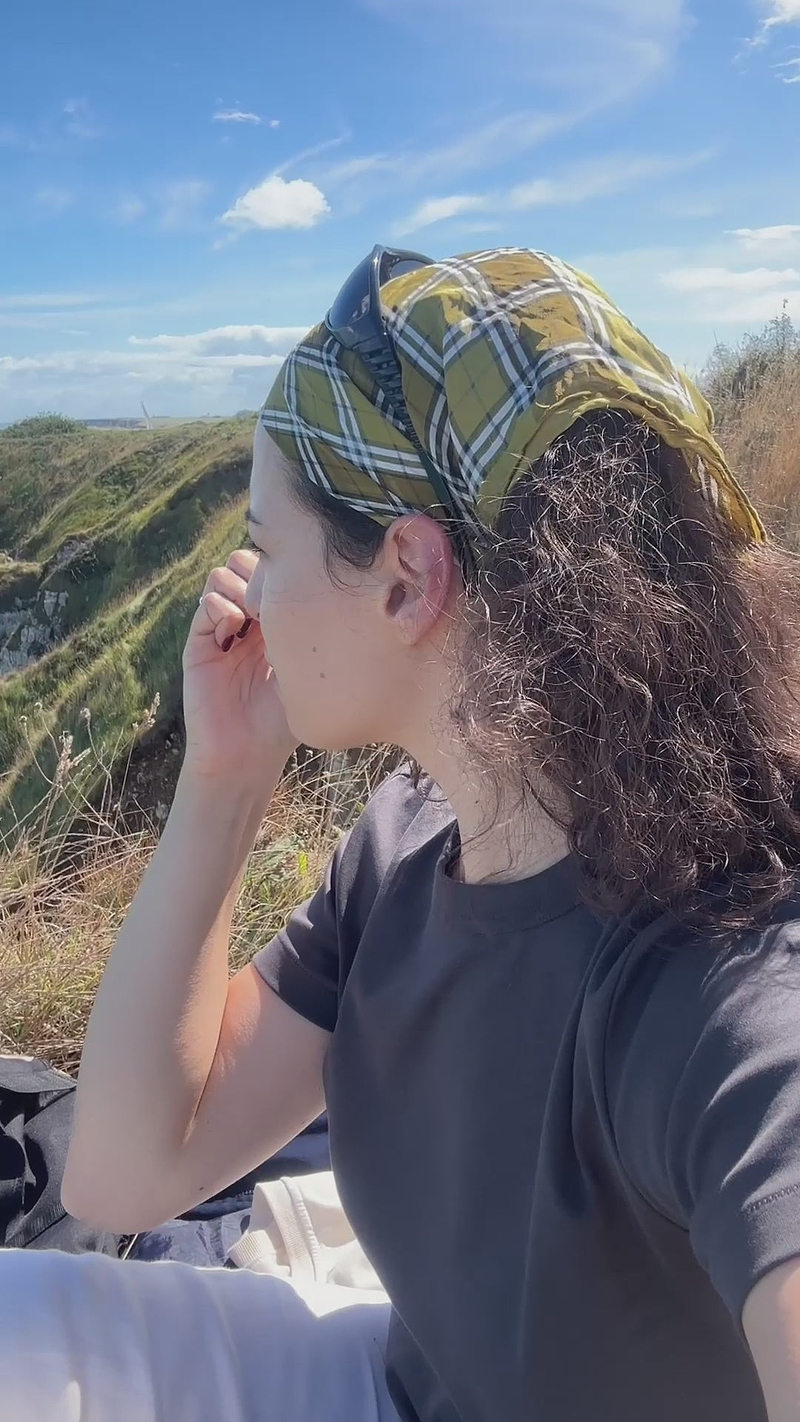 Woman applying SPF50 stick outdoors showcasing the convenient stick format that makes it ideal for outdoor adventures