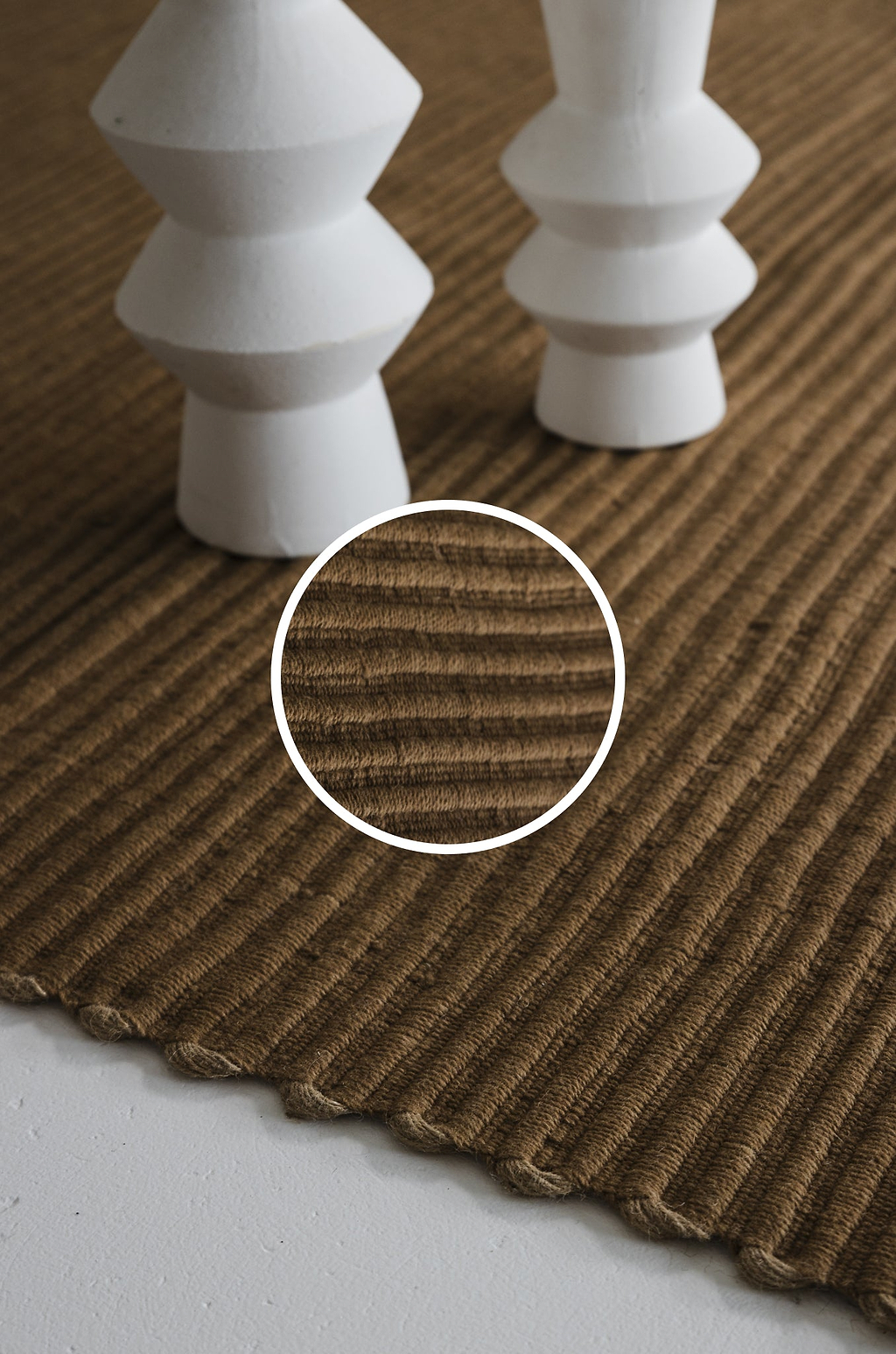 Brown textured rug with white decorative elements on a wooden floor.