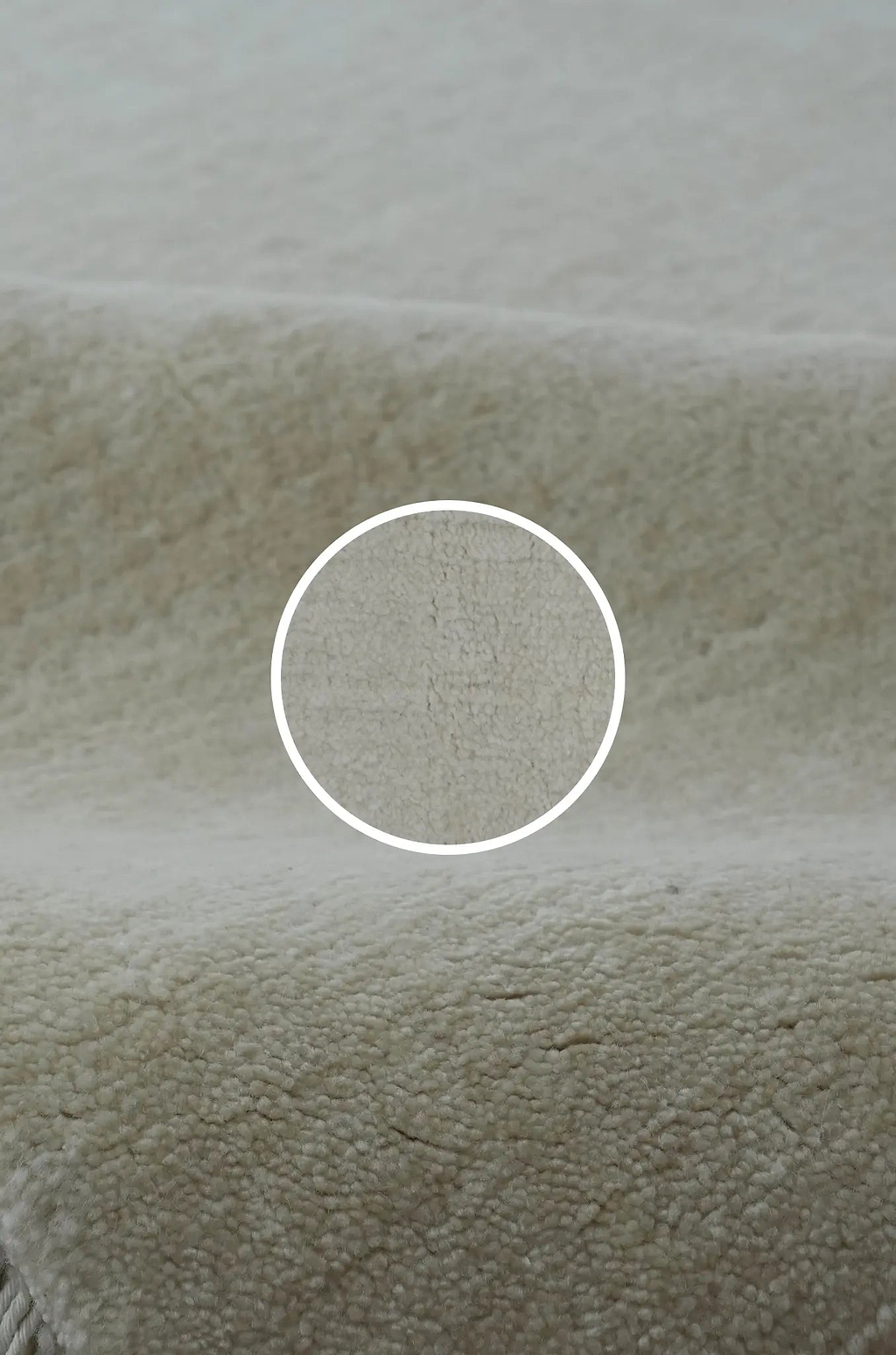 Close-up of New Zealand wool rug by rugs for good with a white circle highlighting the Abrash dyed weave.