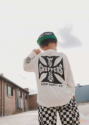 Boy wearing a Little Trouble 'West Coast Choppers' long-sleeve shirt and checkered pants on a rooftop.