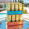 Au Vodka Blue Raspberry and Juicy Peach cans stacked on a mirrored tray outdoors