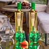 Two Au Vodka Green Watermelon bottles, two green glasses, and a glass decanter with ice