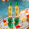Two Au Vodka Watermelon bottles and cocktails on a mirrored tray by a pool