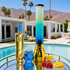 Au Vodka Blue Raspberry bottle and drink dispenser with blue cocktail and fruit garnish by a pool