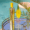 Au Vodka Pineapple Crush bottle and cocktail on a mirrored tray by a pool