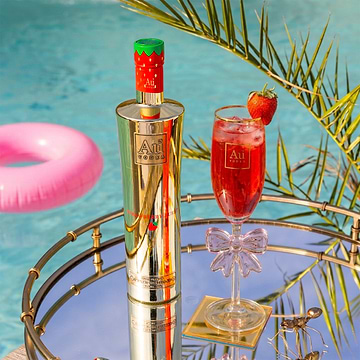 Au Vodka Strawberry Burst bottle and cocktail on a mirrored tray by a pool