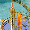 Au Vodka Juicy Peach bottle and cocktail on a mirrored tray by a pool