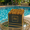 Au Vodka branded box with gold roses on a mirrored tray by a swimming pool