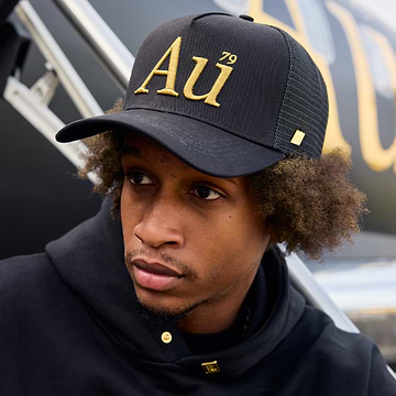 Person wearing an Au signature cap with gold logo on the front