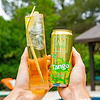 Hands holding a glass of Au Vodka and a can of Au Vodka Tango Apple