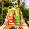 Two Au Vodka Tango cans, orange and apple flavors, held up with water splashing