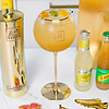 Au Vodka Pineapple Crush bottle with a cocktail in a gold rimmed glass garnished with gummy sweets