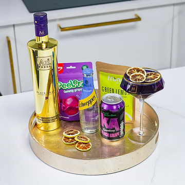 Au Vodka Black Grape bottle, Schweppes lemonade, KA Black Grape, Peelerz Gummy Grapes, and a cocktail