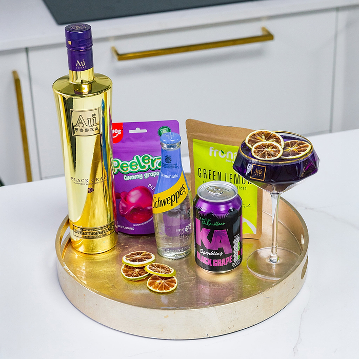 Au Vodka Black Grape bottle, Schweppes lemonade, KA Black Grape, Peelerz Gummy Grapes, and a cocktail