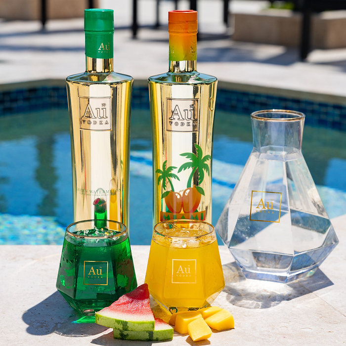 Au Vodka bottles in Green Watermelon and Miami Mango flavors with matching cocktails by a pool