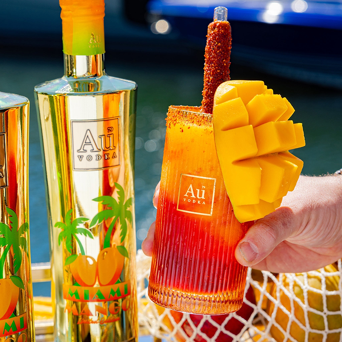 Au Vodka Miami Mango bottle and cocktail with mango garnish and chili-lime straw