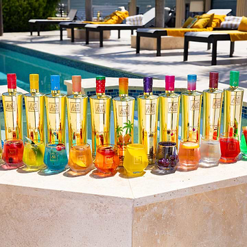 Au Vodka bottles and cocktails in various colors by a pool