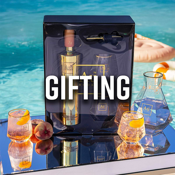 Au Vodka Red Cherry gift set with two glasses, a bottle stopper, and a drink on a gold tray