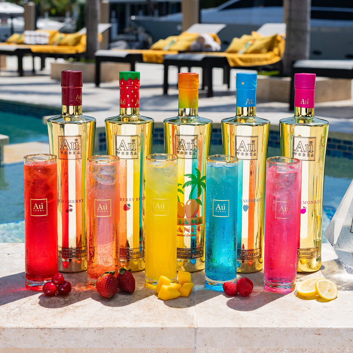 Au Vodka USA bottles and cocktails by a pool with fruit garnishes