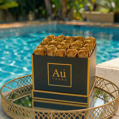 Au Vodka USA merchandise: black box with gold Au Vodka logo and gold roses, on a gold tray by a pool
