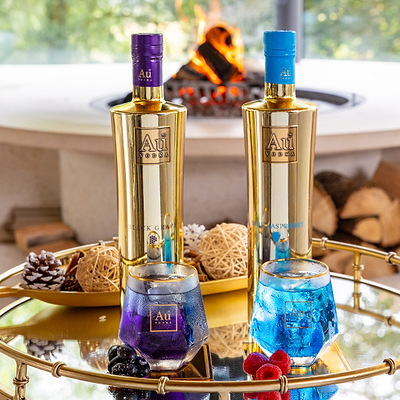 Au Vodka Black Grape and Blue Raspberry bottle bundle with matching cocktails on a gold tray